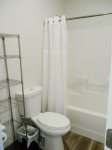 The full size bathroom is spacious with wire shelves to put your belongings on